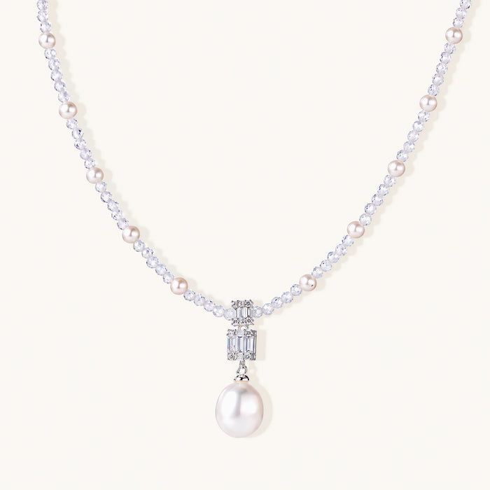 Dainty necklace with lavender crystal beads, freshwater pearls, geometric pendant, and large pearl drop on white background.
