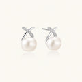 Rhodium-plated silver stud earrings with sparkling X design above lustrous round freshwater pearls on white background.