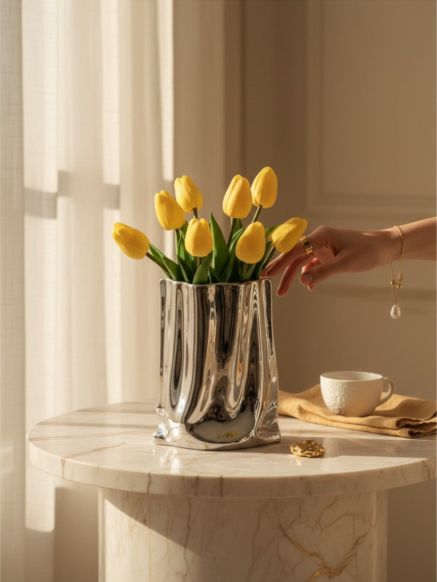 Maison Valentyne ceramiczny wazon z falbankami w kolorze srebrnym z bukietem żółtych tulipanów na marmurowym stole